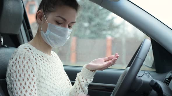 Young woman disinfects her hands with an antibacterial gel after a meeting