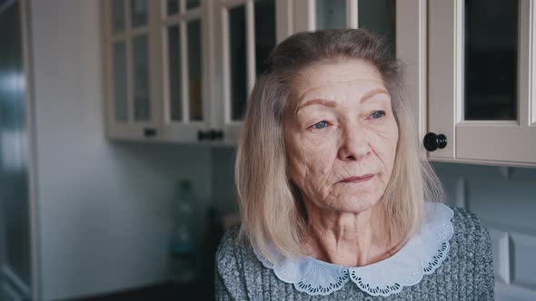 Sad Lonely Old Gray Haired Woman Looking Through the Window