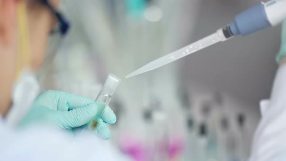 Researcher with Tube and Dropper in the Modern Lab