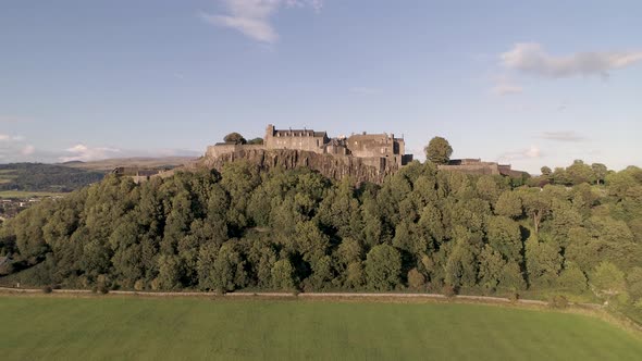 Aerial crane shot up and above Stirling Castle looking North towards the hills on a clear and sunny