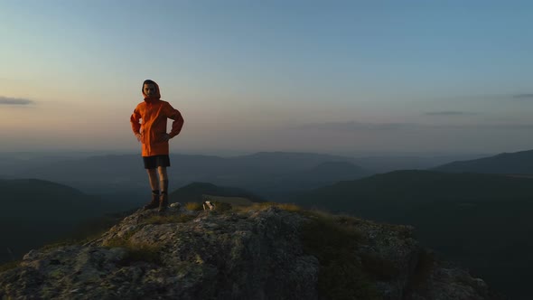 Backpacker with Orange Jacket Shadowing Eyes