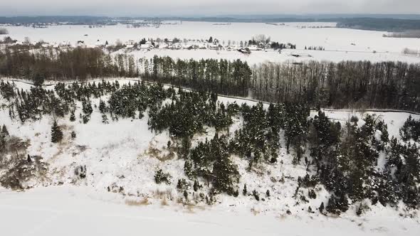 Side flying view of Kadagiai slenis in Lithuania covered in snow