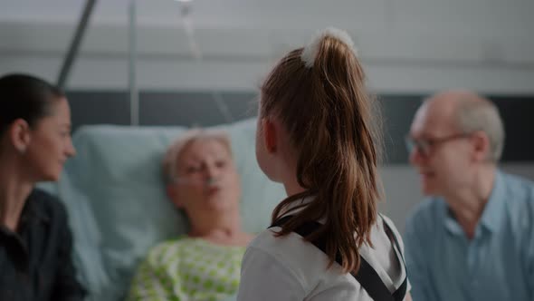 Close Up of Little Girl Talking to Sick Patient in Bed at Family Visit