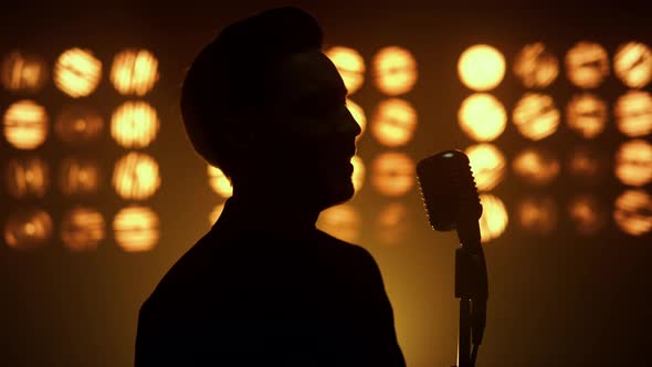Silhouette Singing Man Vocalist Using Microphone on Show Stage Nightclub Closeup