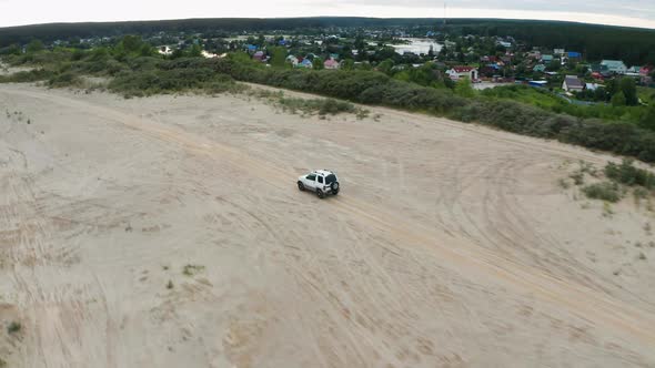 Aerial View of a Car Driving on Sand