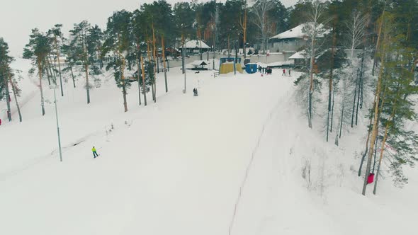 People in Ski Suits Go Up with Rope Tow To Lift Station Top