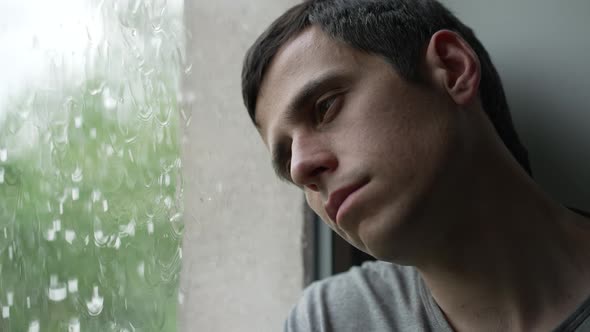 Sad Man Looks Outside the Window