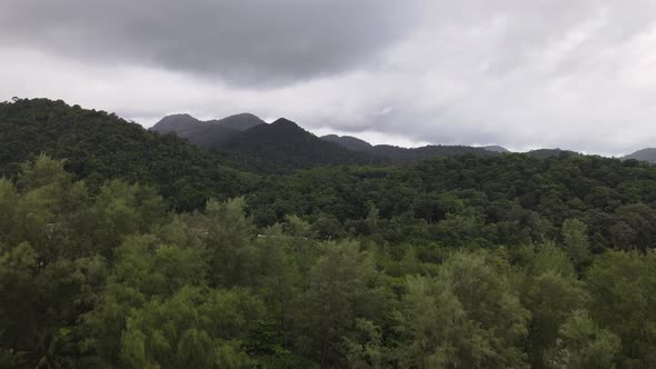 Ascending aerial view of mountain range on cloudy day