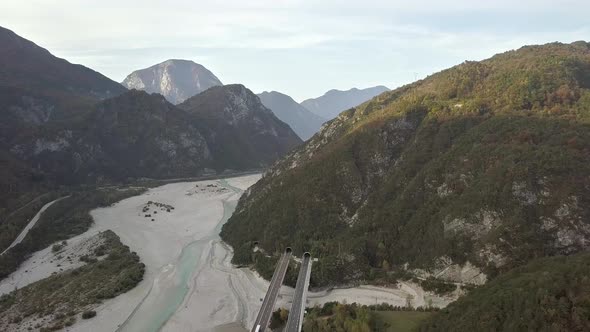 Aerial view of freeway interstate road in italian alps with fast moving traffic and rural green