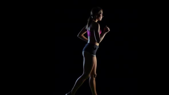 Running Girl Leading a Healthy Lifestyle on a Black Background, Slow Motion