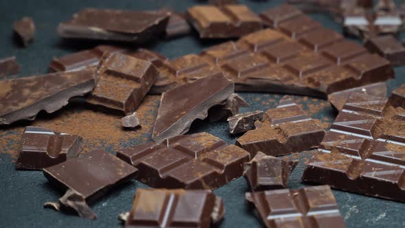 Dark or Milk Organic Chocolate Pieces and Cocoa Powder on Dark Concrete Background