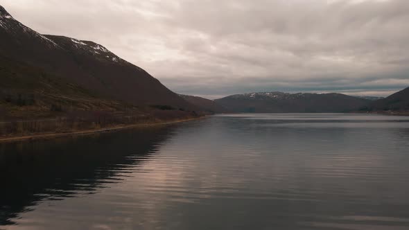 Cloudy Sky Reflections On Calm Waters Of Nordfjorden In Kvaloya Island, Norway. drone shot