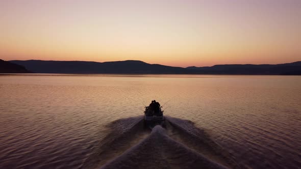 Aerial View of a Fishermens on a Speed Motor Boat Fishing on a Lake with Beautiful Sunrise