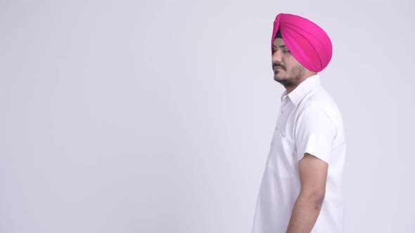 Profile View of Happy Bearded Indian Sikh Man with Arms Crossed