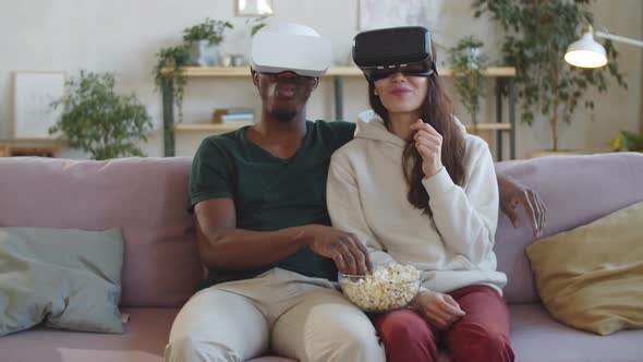 Happy Multiethnic Couple Watching Movie on VR Headsets