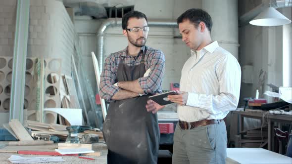 Boss Shows Something To Carpenter on the Tablet alt
