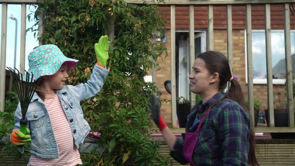 Mother Housewife with Kids Daughter Wear Works Gloves Preparing Soil to Plant Flowers Give Five