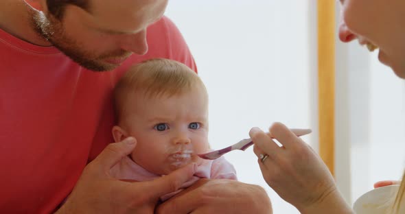 Parents feeding their baby boy at home 4k