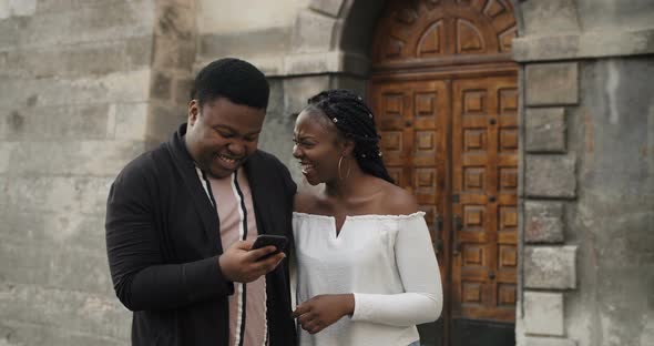 Couple Walking and Using Smarthone.