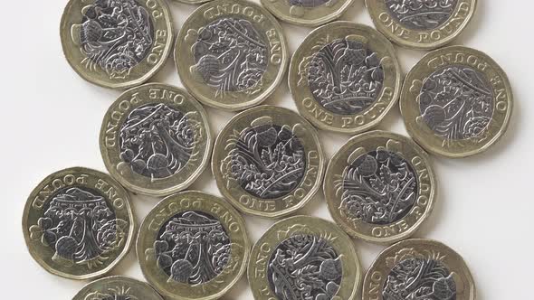 Rotating Reverse Of 2017 British 1 Pound Coins Laid Flat On A White Surface - Top Shot