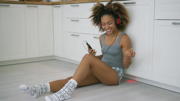 Laughing Woman with Gadgets in Kitchen