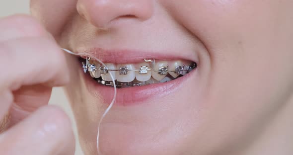 Woman Using Dental Floss Closeup