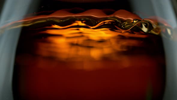 Super Slow Motion Detail Shot of Rippling Whiskey in Glass at 1000Fps alt