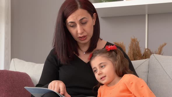 The mother is reading a story to her child.