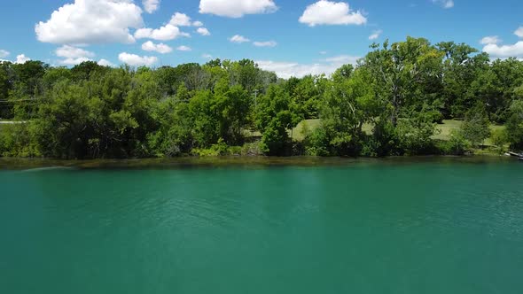 Ascending aerial flight over beautiful Welland river toward epic skyline of Niagara Falls City in Ca