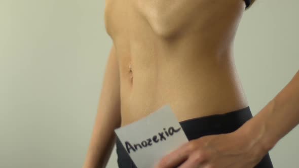 Female Holding Anorexia Note, Undereating, Exhausted Body, Skinny Torso Closeup
