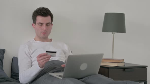 Man with Unsuccessful Online Payment on Laptop in Bed