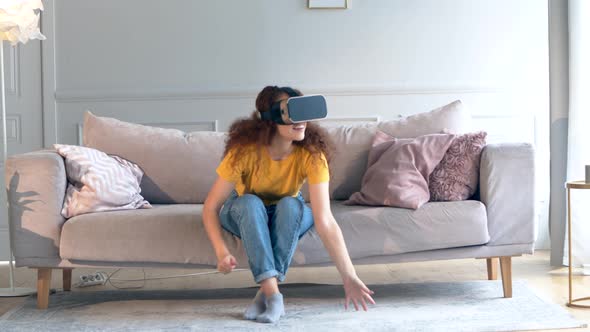 A Girl in VR-glasses Is Moving Hands and Standing Up