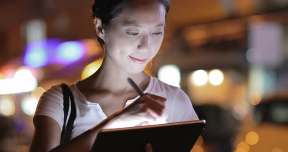 Woman using digital tablet computer at night 