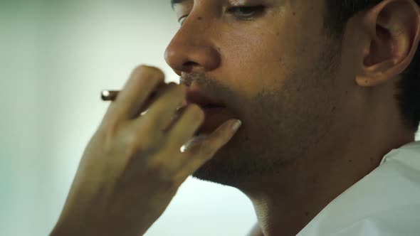 Makeup artist applying lipstick on male models lips