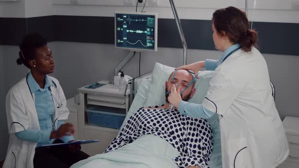 Medical Team Monitoring Heartbeat of Sick Man During Respiratory Appointment