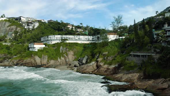 Aerial closing in of the cliff rocks of Joatinga beach in Rio de Janeiro during high tide