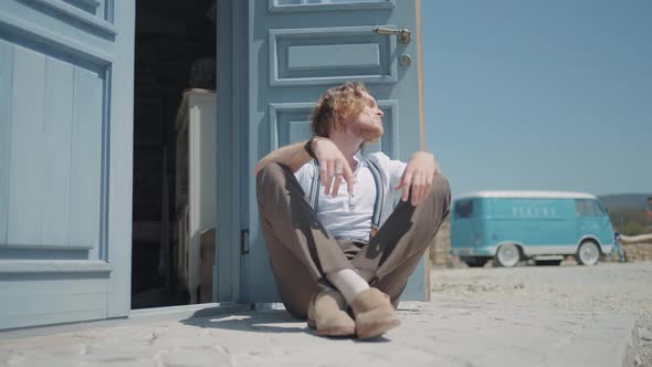 Young man sitting by the door