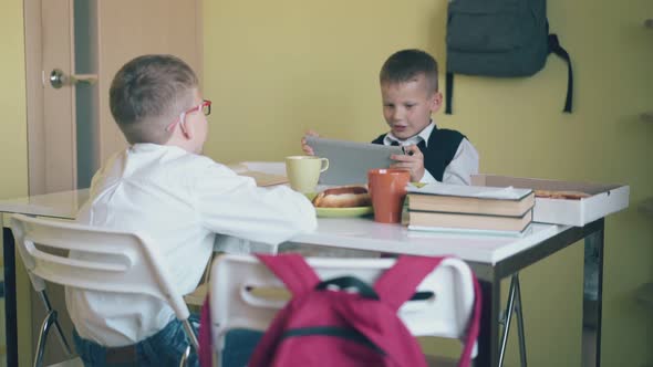 Schoolchildren Sit at Table with Textbooks Food and Drinks