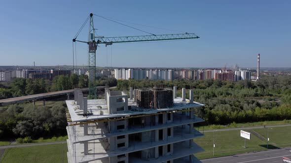 Workers work with crane and steel concrete reinforcement at large construction site