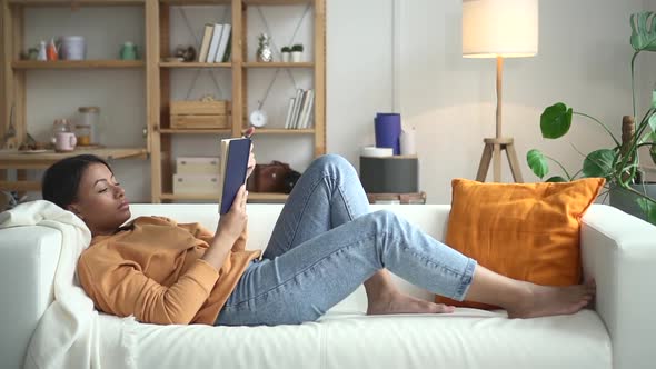 Woman Lie on Sofa and Read Book in Living Room Spbd