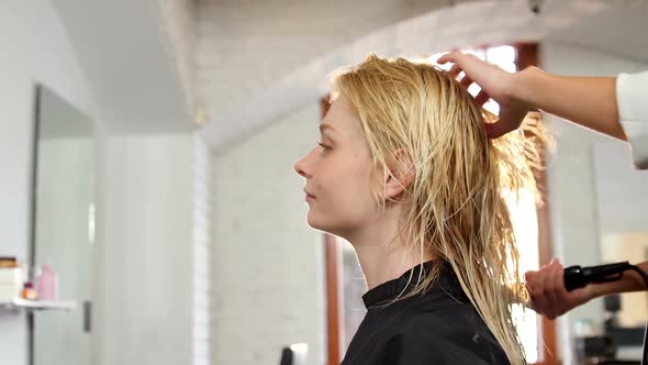 Woman getting her hair dried with hair dryer