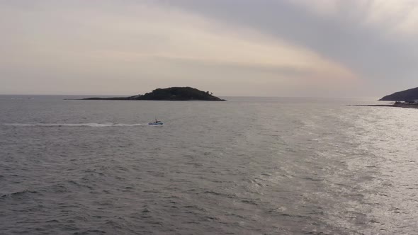 A Fishing Boat Returning To Port At Sunset