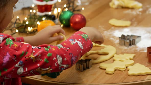 Mom and daughter make gingerbread in the form of a man and a Christmas tree.