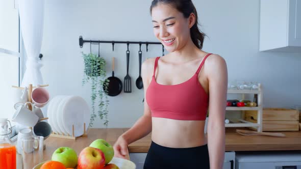 Portrait of Asian attractive woman hold fruit bowl, enjoy eat clean vegetables and look at camera.