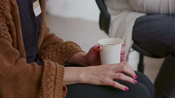 Close Up of Nervous Woman Holding Cup of Coffee and Trembling at Aa Therapy Meeting