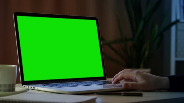Close up green screen mock up on laptop. Freelancer searches for information on internet.