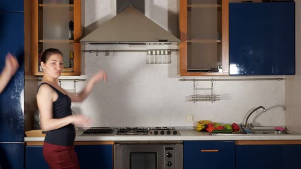 Playful Girl and Guy Dance and Grimace Having Fun in Kitchen