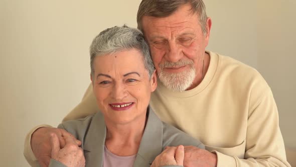 Close Portrait of Smiling Elderly Husband and Wife Looking at Camera