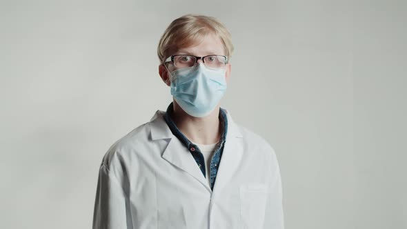 Caucasian Strict Man Doctor in Medical Mask Looking in Camera on White Background Shaking His Finger