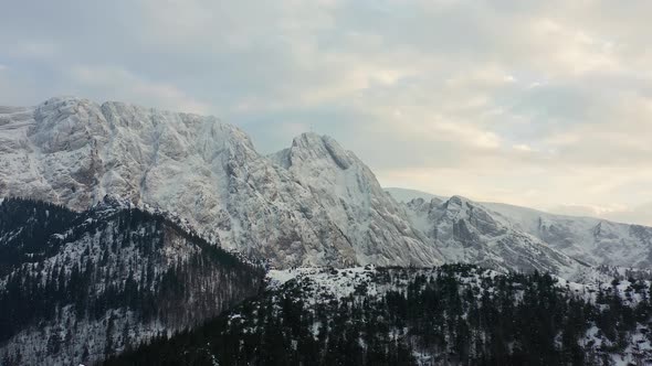 Rough And White Rocky Mountain Facade And Snow-capped Forest In Winter Day in Poland - aerial shot